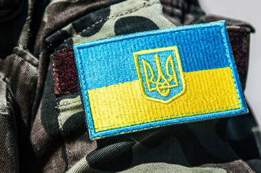 Military personnel wearing badge of Ukrainian army with trident and yellow-blue flag