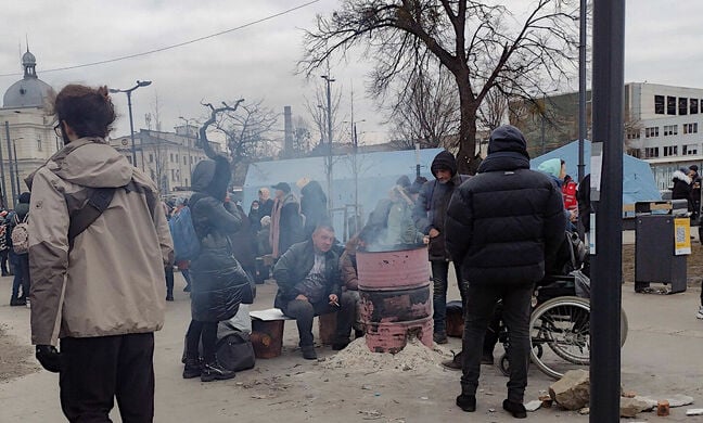 People keep warm around an oil drum fire in Lviv. Pic: Vic Harkness