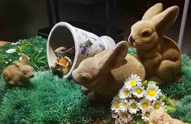 Photo of toy Easter bunnies having fun as seen through a shop window