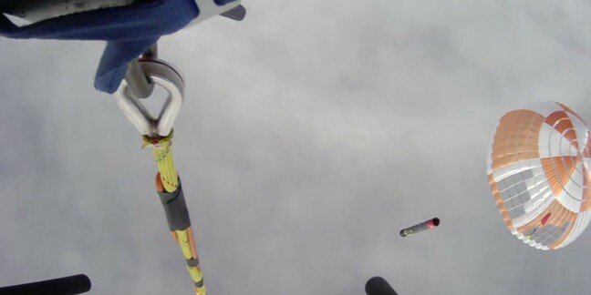 View from recovery helicopter of Electron booster returning to Earth under parachute after launch