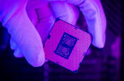 A gloved engineer's hand holding a modern Intel Core processor