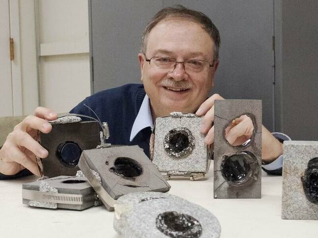 Paul Woskov shows off test drill holes made with a gyrotron