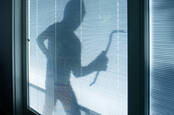 Silhouette of personification carrying a crowbar by immoderate windows