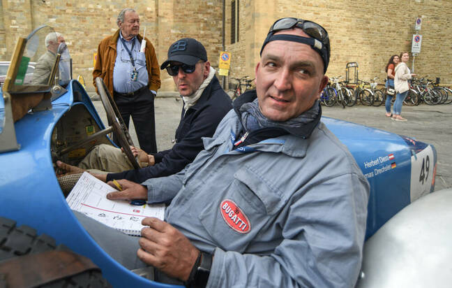 Herbert Diess (left) drives a 1928 Bugatti (with navigator Jon Drechsler on the right) in the 2019 Mille Miglia in Florence, Italy.