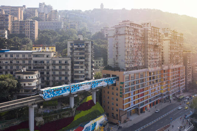 Aerial view of train at Liziba station in Chongqing, China, passing through building