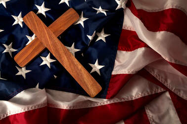 A Christian cross lying over a USA flag