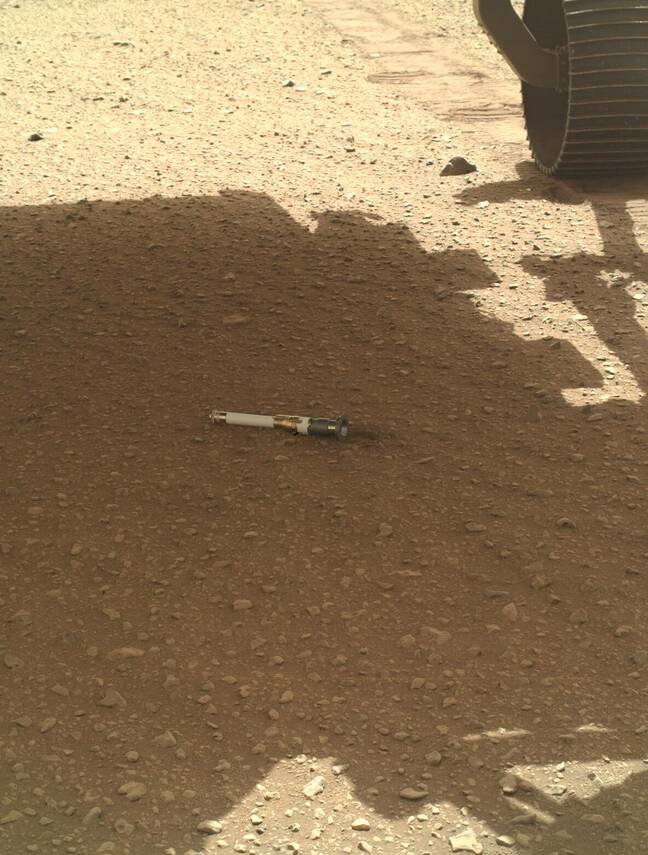 Le rover Perseverance de la NASA dépose un tube d'échantillon sur le sol.