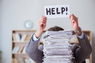 Man hidden behind stack of paper