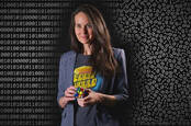 CISA director Jen Easterley standing in front of some binary code