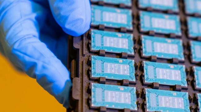 An Intel tech holds a tray of unpopulated packages built using glass substrates 