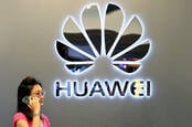 Someone on a phone in front of a Huawei logo