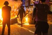Southport merseyside UK July 30th 2024, protestor stands near burning barricade facing riot police with brick in hand. Southport riot.