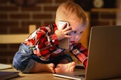 Toddler working with computer and smartphone